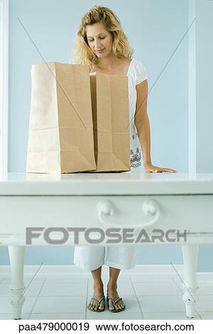 Woman looking into grocery bag View Large Photo Image Stock Photo - Woman looking into grocery bag. Fotosearch