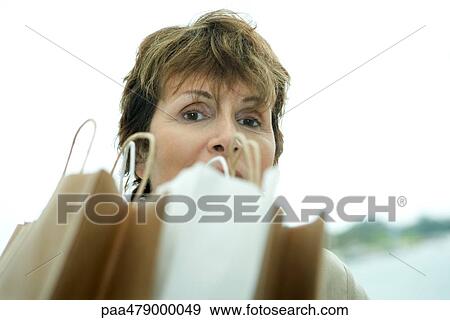 Woman looking over shopping bags View Large Photo Image Stock Photo - Woman looking over shopping bags. Fotosearch
