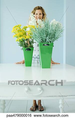 Woman standing behind cut flowers, smiling, full length View Large Photo Image Stock Photograph - Woman standing behind cut flowers, smiling, full length. Fotosearch