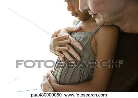 Grandmother embracing granddaughter, cropped side view View Large Photo Image Stock Image - Grandmother embracing granddaughter, cropped side view. Fotosearch