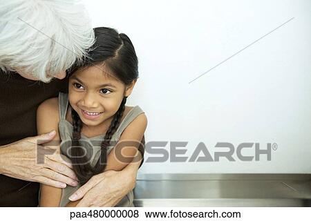 Stock Photo - Grandmother embracing granddaughter, close-up. Fotosearch