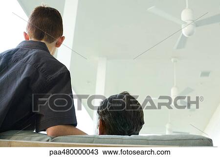 Man and boy side by side on couch, rear view View Large Photo Image Stock Image - Man and boy side by side on couch, rear view. Fotosearch