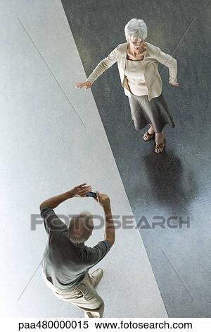 Man photographing wife with digital camera, viewed from directly above View Large Photo Image Stock Photography - Man photographing wife with digital camera, viewed from directly above. Fotosearch