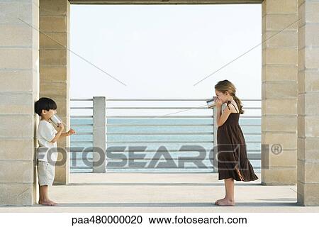 Two children communicating with tin can phones, side view View Large Photo Image Stock Image - Two children communicating with tin can phones, side view. Fotosearch