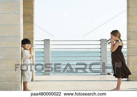 Two children playing with tin can phone, side view View Large Photo Image Stock Image - Two children playing with tin can phone, side view. Fotosearch
