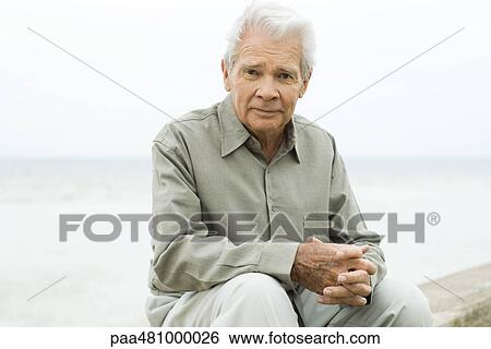 Senior man sitting outdoors, smiling at camera, portrait View Large Photo Image Stock Photograph - Senior man sitting outdoors, smiling at camera, portrait. Fotosearch