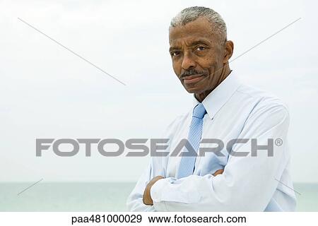 Senior man wearing tie outdoors, arms folded, looking at camera View Large Photo Image Stock Photo - Senior man wearing tie outdoors, arms folded, looking at camera. Fotosearch