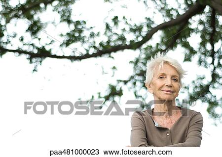 Senior woman smiling at camera outdoors, portrait View Large Photo Image Stock Image - Senior woman smiling at camera outdoors, portrait. Fotosearch