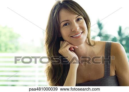 Woman smiling at camera, hand under chin, portrait View Large Photo Image Stock Photo - Woman smiling at camera, hand under chin, portrait. Fotosearch