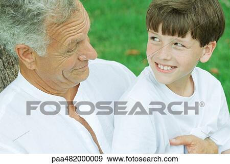 Grandfather and grandson smiling at each other, portrait View Large Photo Image Stock Photo - Grandfather and grandson smiling at each other, portrait. Fotosearch