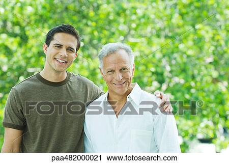 Mature man and adult son smiling at camera together outdoors, portrait View Large Photo Image Stock Image - Mature man and adult son smiling at camera together outdoors, portrait. Fotosearch