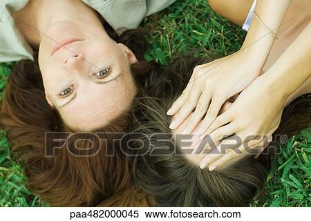 Mother and teen daughter lying on the ground together, girl covering face with hands, woman smiling at camera View Large Photo Image Stock Photography - Mother and teen daughter lying on the ground together, girl covering face with hands, woman smiling at camera. Fotosearch