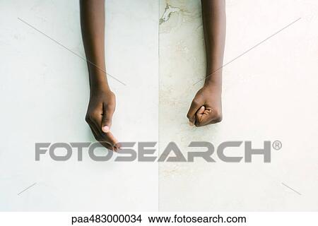 Cropped view of child's arms, one hand cupped, the other making a fist View Large Photo Image Picture - Cropped view of child's arms, one hand cupped, the other making a fist. Fotosearch
