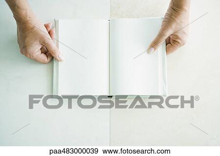 Cropped view of hands holding open book, viewed from directly above View Large Photo Image Stock Photo - Cropped view of hands holding open book, viewed from directly above. Fotosearch