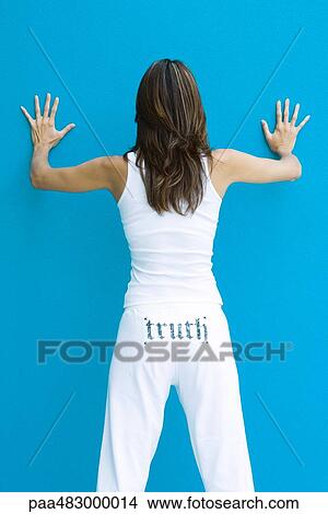 Female standing with hands on wall, wearing pants with the word "truth" printed across backside View Large Photo Image Picture - Female standing with hands on wall, wearing pants with the word "truth" printed across backside. Fotosearch