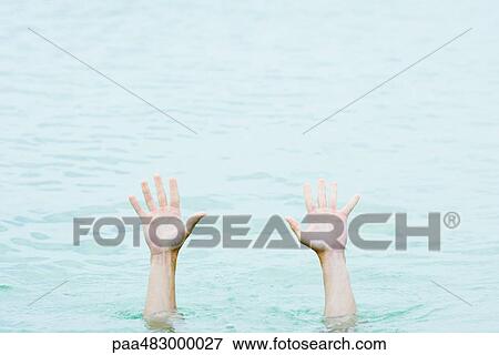 Stock Photo - Hands rising out of water, cropped view. Fotosearch