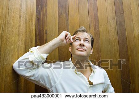 Man touching forehead, looking up, front view View Large Photo Image Stock Image - Man touching forehead, looking up, front view. Fotosearch