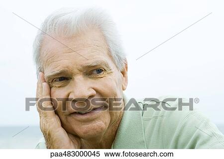 Senior man with hand on cheek, smiling, looking away View Large Photo Image Stock Photography - Senior man with hand on cheek, smiling, looking away. Fotosearch