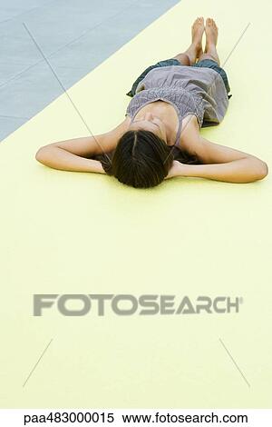 Teenage girl lying on the ground with hands behind head View Large Photo Image Stock Photography - Teenage girl lying on the ground with hands behind head. Fotosearch