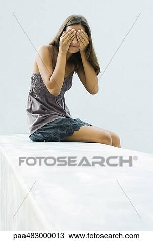 Teenage girl sitting, covering eyes with hands View Large Photo Image Stock Image - Teenage girl sitting, covering eyes with hands. Fotosearch