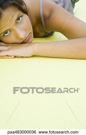 Teenage girl with head resting on arms, looking at camera, cropped view View Large Photo Image Stock Photograph - Teenage girl with head resting on arms, looking at camera, cropped view. Fotosearch
