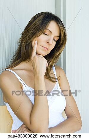 Woman touching face, hand under chin, looking down View Large Photo Image Stock Photo - Woman touching face, hand under chin, looking down. Fotosearch