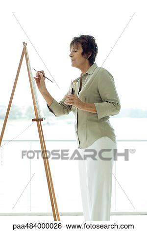 Senior woman painting canvas, side view View Large Photo Image Stock Photograph - Senior woman painting canvas, side view. Fotosearch
