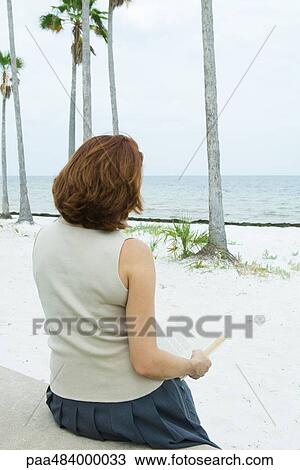 Woman reading book at the beach, rear view View Large Photo Image Stock Image - Woman reading book at the beach, rear view. Fotosearch