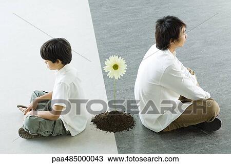 Boy and man sitting back to back, a single flower between them View Large Photo Image Stock Image - Boy and man sitting back to back, a single flower between them. Fotosearch