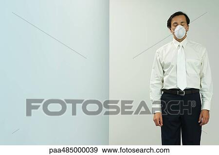Businessman wearing pollution mask, eyes closed, front view View Large Photo Image Stock Photo - Businessman wearing pollution mask, eyes closed, front view. Fotosearch