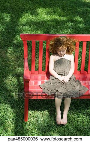 Girl sitting on red bench, high angle view View Large Photo Image Stock Photograph - Girl sitting on red bench, high angle view. Fotosearch