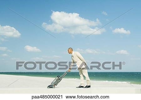 Man in suit using vacuum cleaner on beach, full length View Large Photo Image Stock Image - Man in suit using vacuum cleaner on beach, full length. Fotosearch