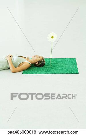 Woman lying with head on square of artificial turf View Large Photo Image Stock Photo - Woman lying with head on square of artificial turf. Fotosearch