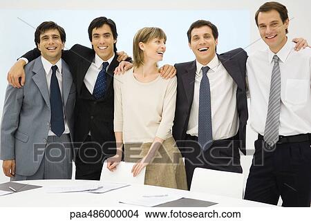 Picture - Team of business associates standing with arms around each other, smiling, group portrait. Fotosearch