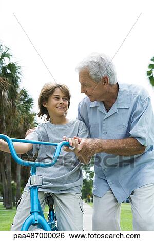 Grandfather teaching grandson to ride bicycle, front view View Large Photo Image Stock Photograph - Grandfather teaching grandson to ride bicycle, front view. Fotosearch
