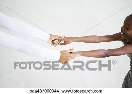 Little girl holding woman's hands, arms outstretched, cropped view View Large Photo Image Picture - Little girl holding woman's hands, arms outstretched, cropped view. Fotosearch