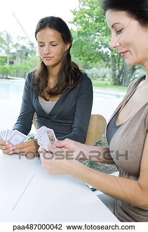 Mother and daughter playing cards together, both looking down View Large Photo Image Stock Image - Mother and daughter playing cards together, both looking down. Fotosearch