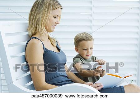 Mother and son reading book together, both smiling View Large Photo Image Stock Photo - Mother and son reading book together, both smiling. Fotosearch
