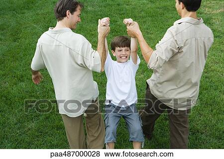 Two men carrying boy by his arms, high angle view View Large Photo Image Stock Photo - Two men carrying boy by his arms, high angle view. Fotosearch