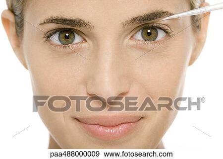 Woman applying make-up, smiling at camera View Large Photo Image Stock Photo - Woman applying make-up, smiling at camera. Fotosearch