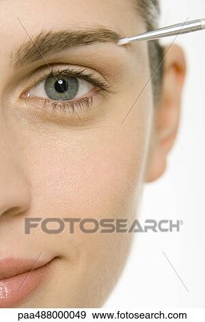 Woman applying make-up to eyebrow, cropped view, close-up View Large Photo Image Stock Photo - Woman applying make-up to eyebrow, cropped view, close-up. Fotosearch