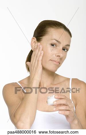 Woman applying moisurizer to face View Large Photo Image Stock Photograph - Woman applying moisurizer to face. Fotosearch