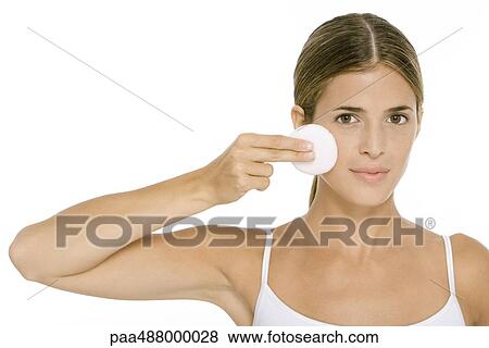 Woman holding up cotton pad to cheek, looking at camera View Large Photo Image Stock Photo - Woman holding up cotton pad to cheek, looking at camera. Fotosearch
