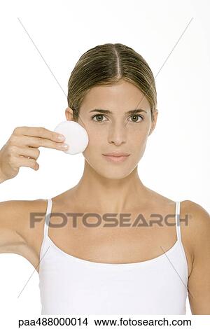 Woman holding up cotton pad to face, looking at camera View Large Photo Image Picture - Woman holding up cotton pad to face, looking at camera. Fotosearch
