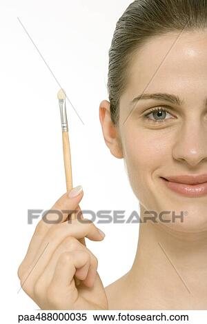Woman holding up make-up brush View Large Photo Image Stock Photography - Woman holding up make-up brush. Fotosearch