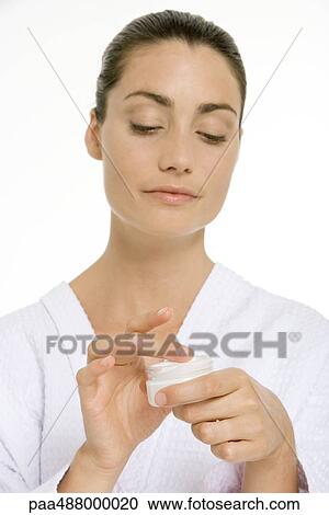 Woman in bathrobe dipping finger into jar of skin cream View Large Photo Image Stock Image - Woman in bathrobe dipping finger into jar of skin cream. Fotosearch