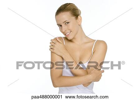 Woman in tank top touching shoulder and arm, smiling at camera View Large Photo Image Stock Image - Woman in tank top touching shoulder and arm, smiling at camera. Fotosearch