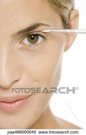 Woman putting on eye make-up, cropped view of face, close-up View Large Photo Image Stock Photography - Woman putting on eye make-up, cropped view of face, close-up. Fotosearch
