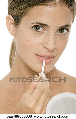 Woman putting on lip gloss View Large Photo Image Stock Photo - Woman putting on lip gloss. Fotosearch