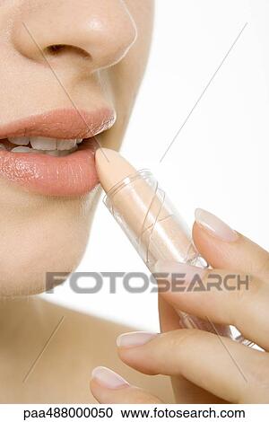 Woman putting on lipstick, cropped view, extreme close-up View Large Photo Image Stock Image - Woman putting on lipstick, cropped view, extreme close-up. Fotosearch